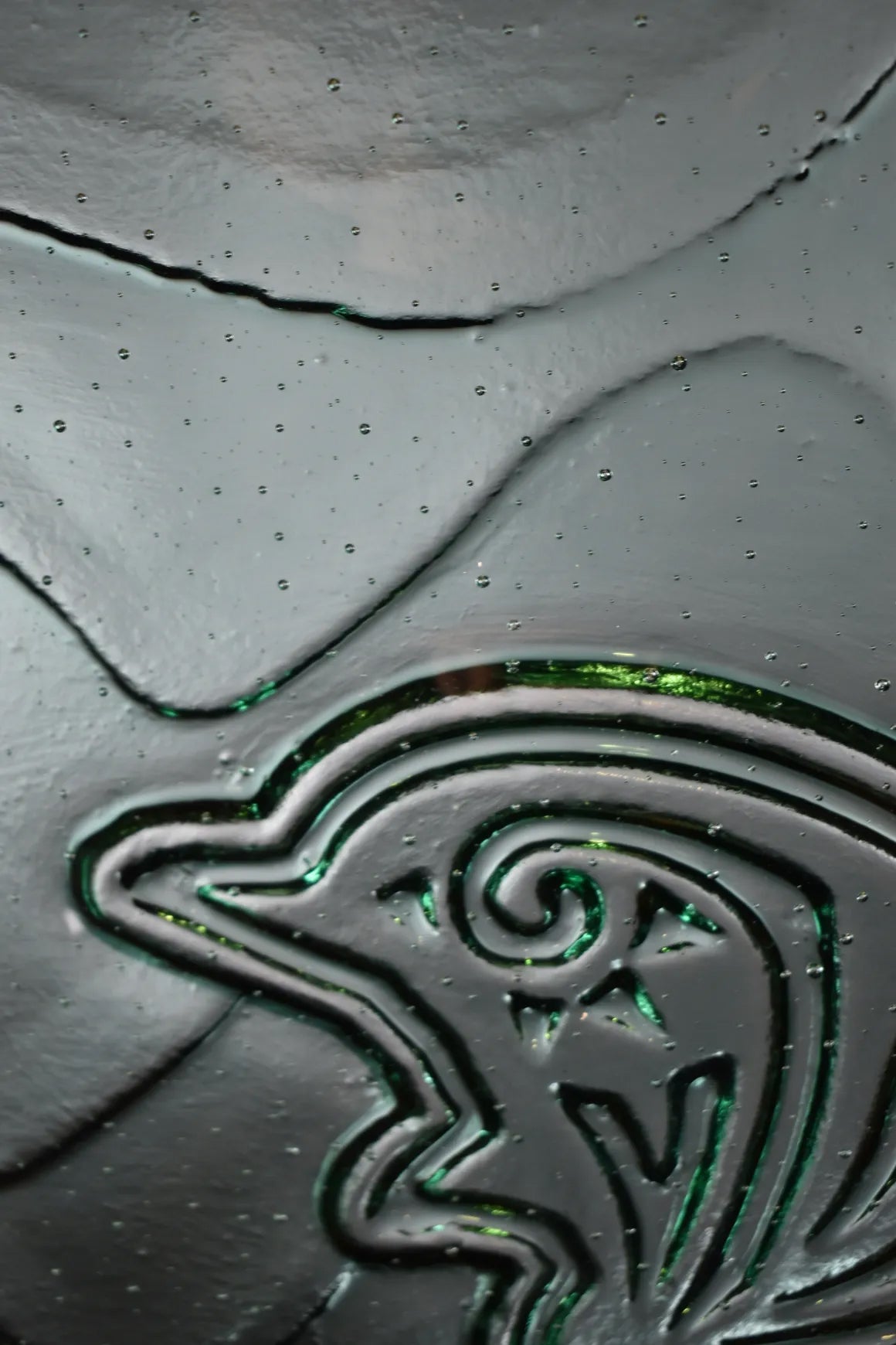 ロジャー・ポーリー作「ガラスのタトゥーアート『ナイア(イルカ)』」